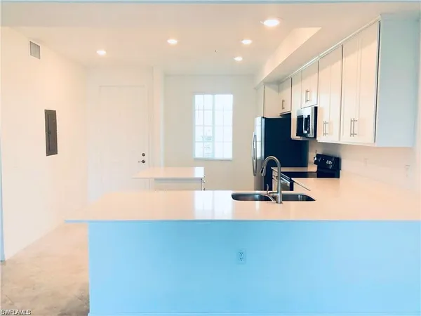 a view of a kitchen with kitchen island a sink wooden floor and a counter top space
