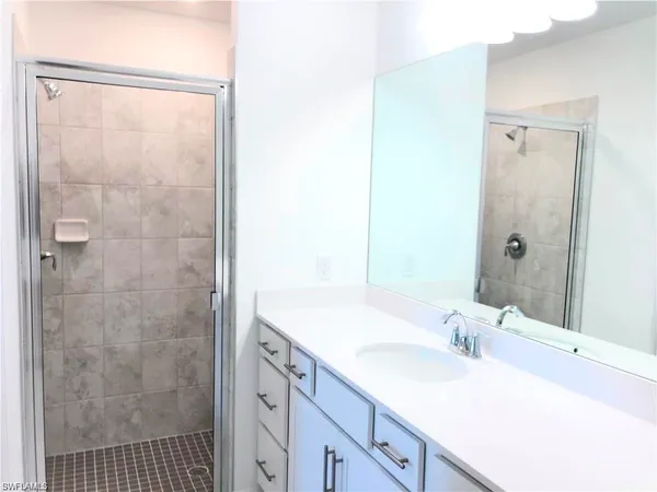 a bathroom with a sink a shower and a mirror