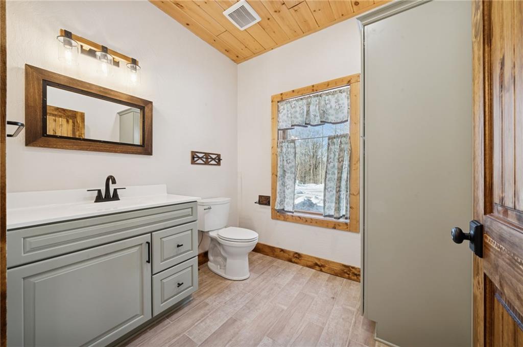 223 Deer Fern Drive Somerset, PA 15501 - Photo 9 of 37 a bathroom with a toilet a sink a mirror and a window