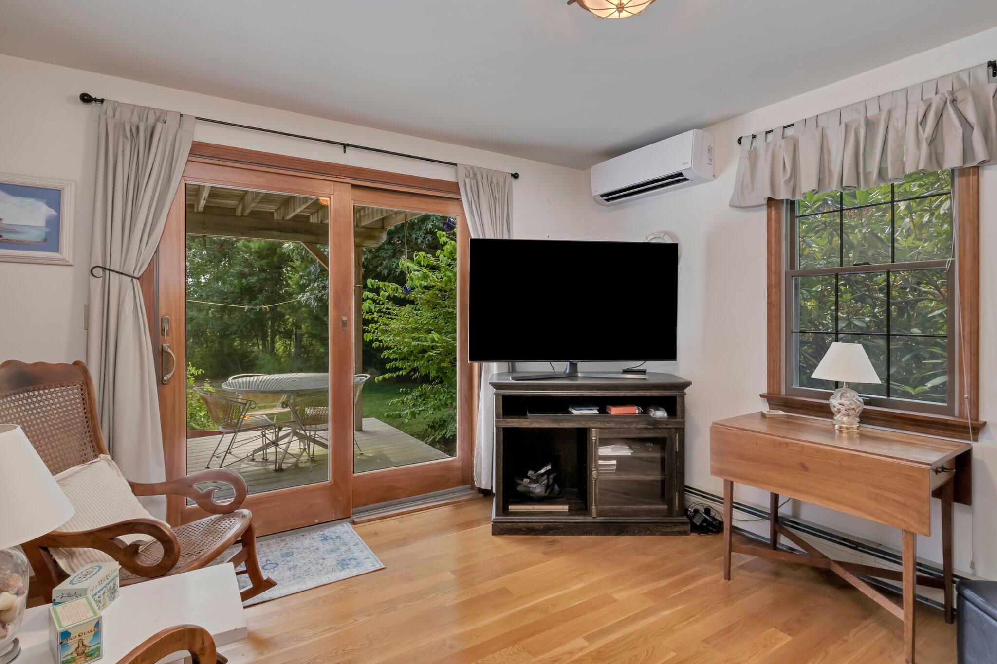 106 Castle Road Truro, MA 02666 - Photo 22 of 47 a living room with furniture a flat screen tv and a floor to ceiling window