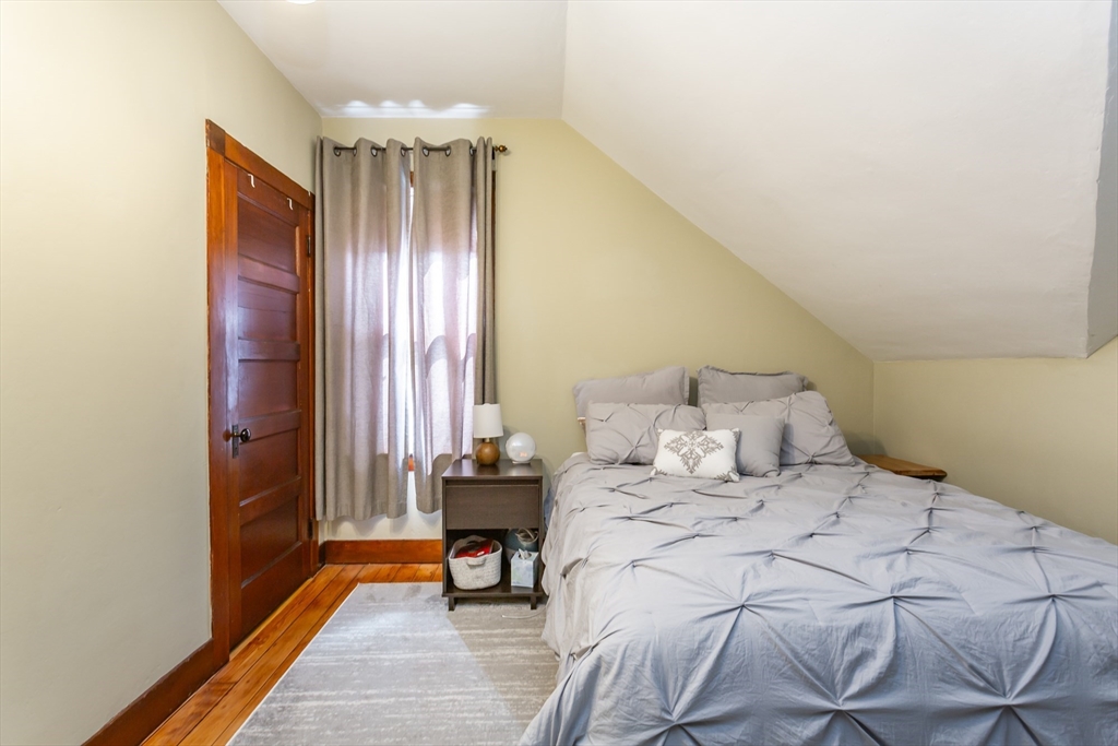 256 Maple Street Fall River, MA 02720 - Photo 32 of 41 a bedroom with a bed and a chandelier