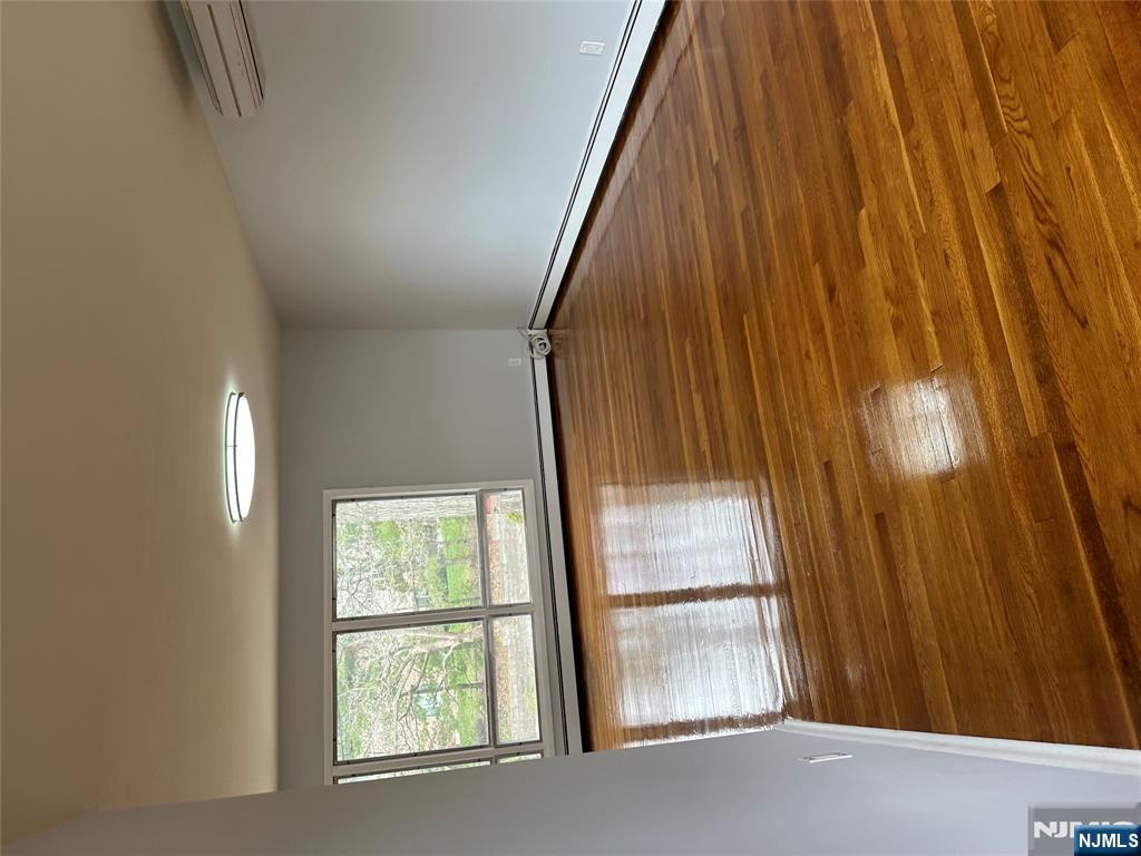 1032 Glen Road Fort Lee, NJ 07024 - Photo 6 of 16 a view of empty room with wooden floor and fan