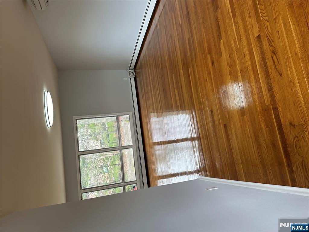1032 Glen Road Fort Lee, NJ 07024 - Photo 7 of 16 a view of empty room with wooden floor and fan