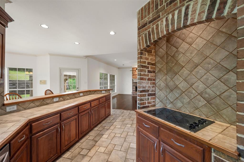 5607 Ranger Drive Rockwall, TX 75032 - Photo 17 of 40 Kitchen featuring a built-in cooktop, tile flooring, and extensive wood cabinetry