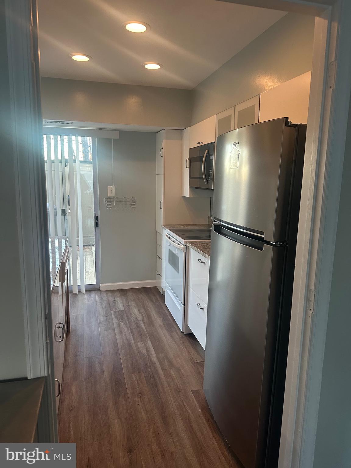 326 Lancaster Square, Unit 326 Sterling, VA 20164 - Photo 12 of 30 a kitchen with stainless steel appliances a refrigerator and a wooden floor