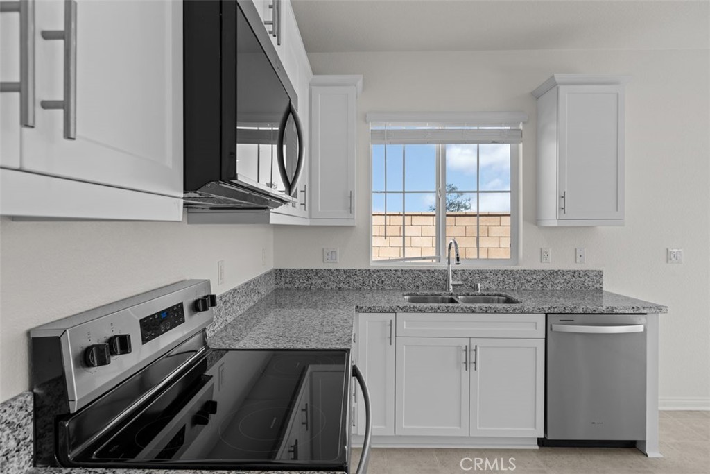 1218 Butterfly Way Banning, CA 92220 - Photo 16 of 16 a kitchen with granite countertop a stove sink and cabinets