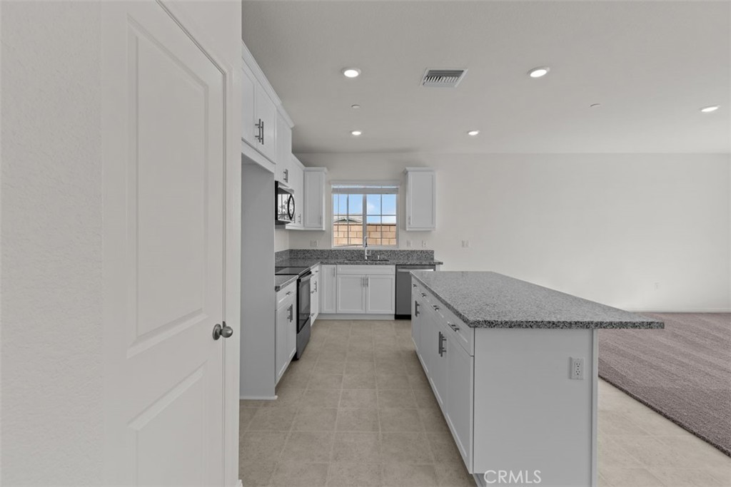 1218 Butterfly Way Banning, CA 92220 - Photo 4 of 16 a kitchen with stainless steel appliances granite countertop a sink and cabinets