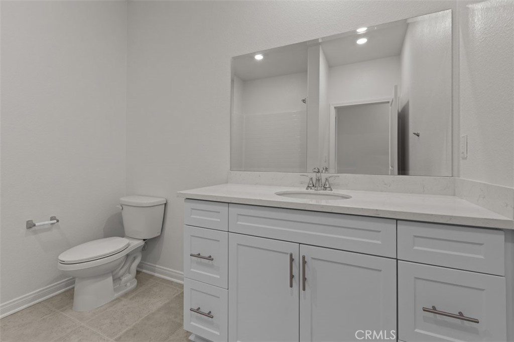 1218 Butterfly Way Banning, CA 92220 - Photo 6 of 16 a bathroom with a granite countertop sink a toilet and a mirror