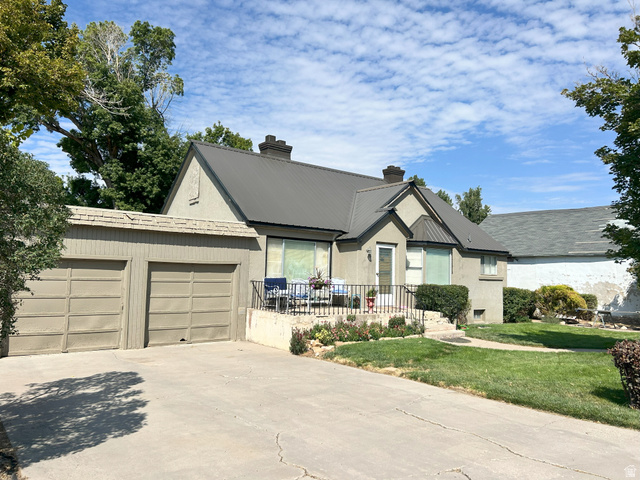 40 South State Street Scipio, UT 84656 - Photo 2 of 39 View of front of property featuring a chimney, concrete driveway, a front lawn, and a metal roof