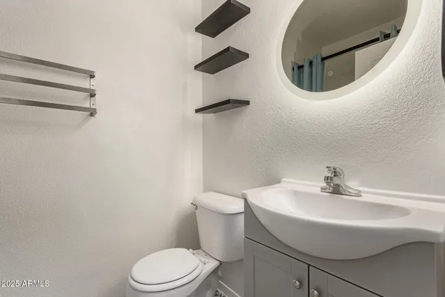 a bathroom with a sink a toilet and mirror