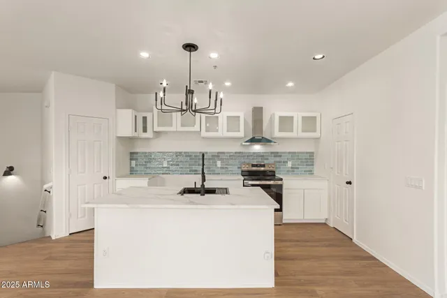 a kitchen with kitchen island a stove a sink a refrigerator and cabinets