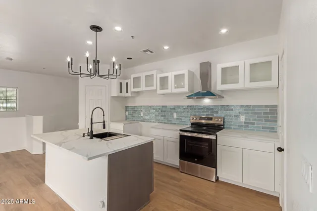 a kitchen with stainless steel appliances granite countertop a sink stove and cabinets