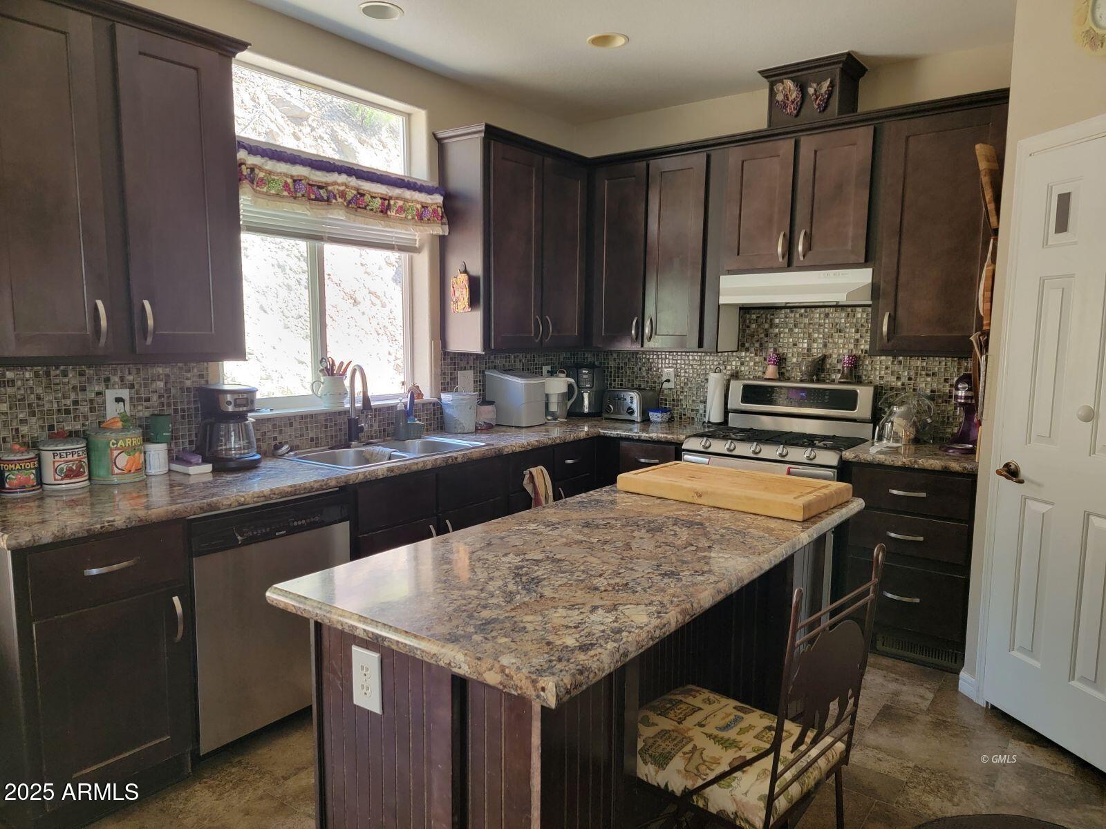 9383 Kellner Canyon Road Globe, AZ 85501 - Photo 7 of 32 a kitchen with a sink a stove a kitchen island and a window