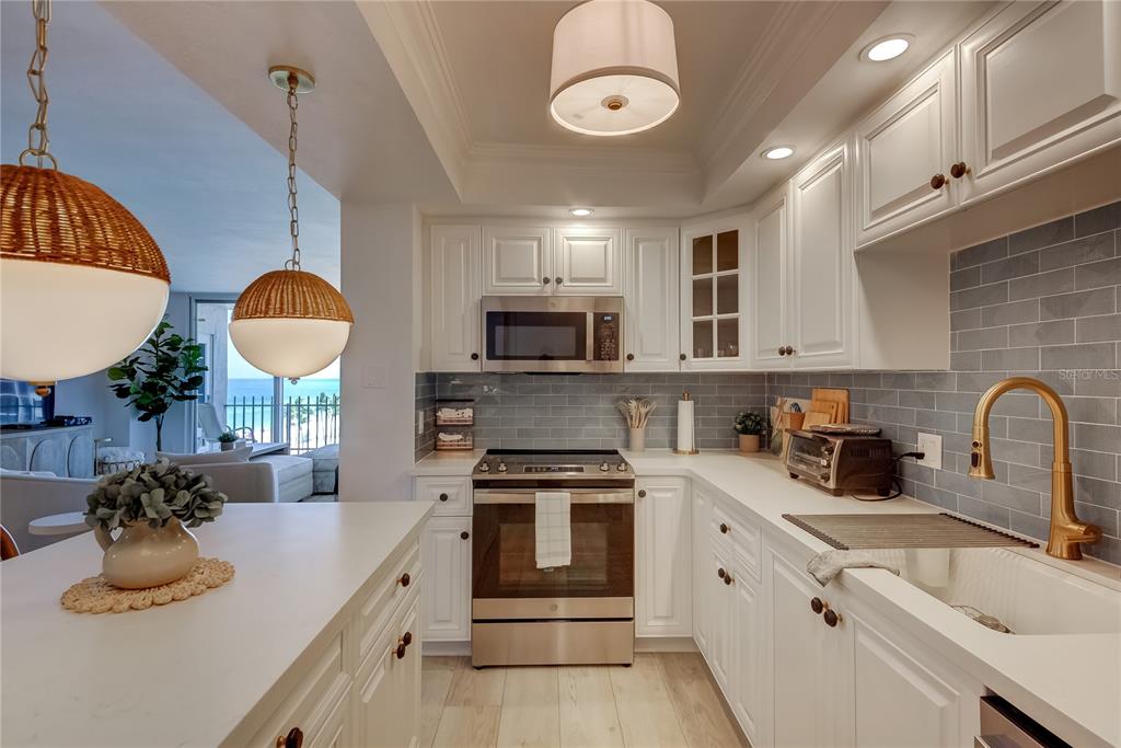 1212 Benjamin Franklin Drive, Unit 504 Sarasota, FL 34236 - Photo 18 of 48 a kitchen with kitchen island granite countertop a sink a stove and cabinets