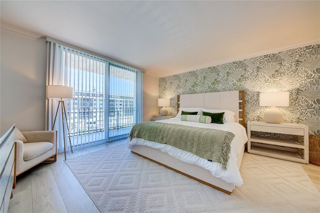 1212 Benjamin Franklin Drive, Unit 504 Sarasota, FL 34236 - Photo 19 of 48 a spacious bedroom with a bed and a couch