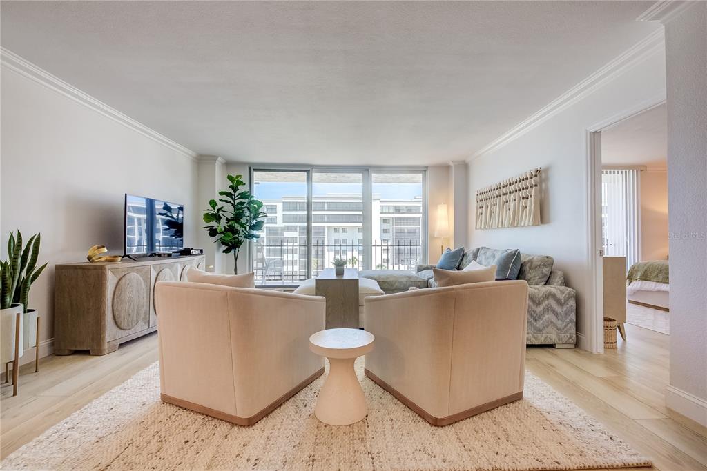 1212 Benjamin Franklin Drive, Unit 504 Sarasota, FL 34236 - Photo 8 of 48 a living room with furniture a large window and a dining table