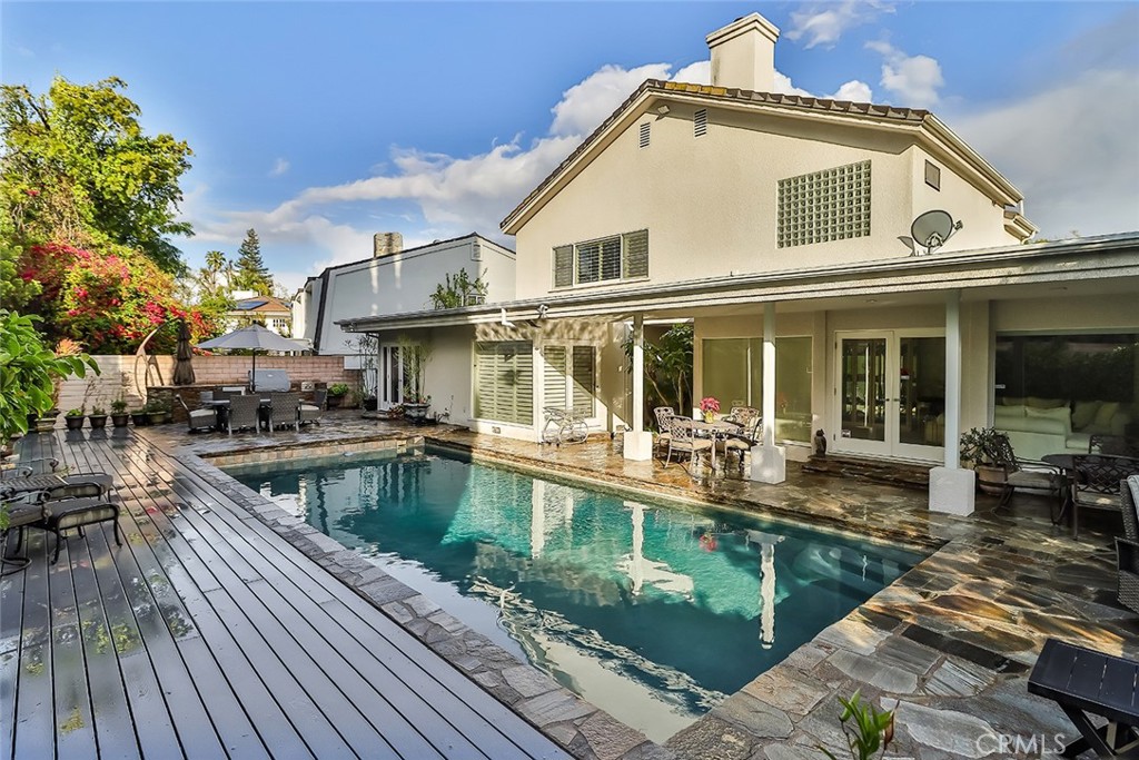 a white house with a large pool and glass windows