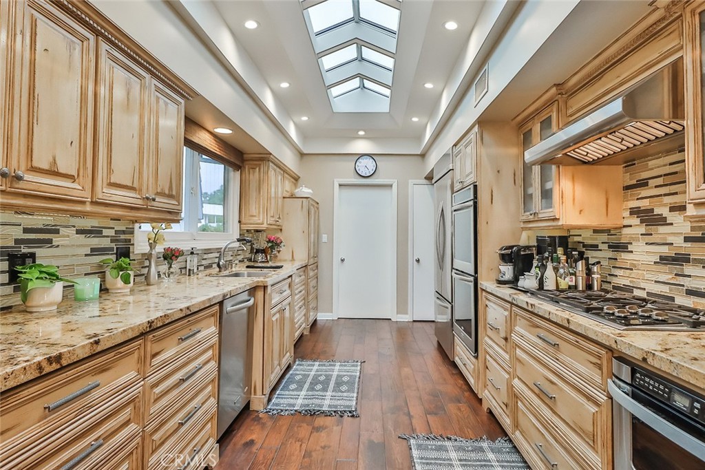 4575 De Celis Place Encino, CA 91436 - Photo 23 of 63 a kitchen with stainless steel appliances granite countertop a stove and a sink