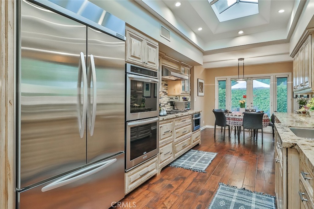 4575 De Celis Place Encino, CA 91436 - Photo 27 of 63 a kitchen with granite countertop a refrigerator and a stove top oven
