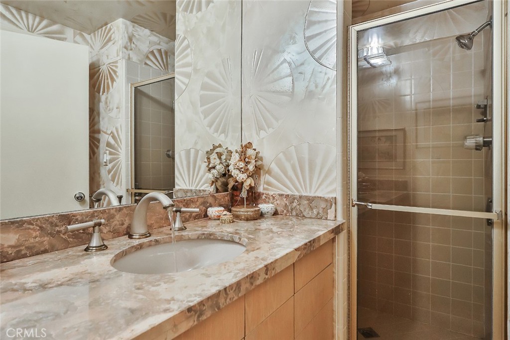 4575 De Celis Place Encino, CA 91436 - Photo 31 of 63 a bathroom with a granite countertop sink and a mirror