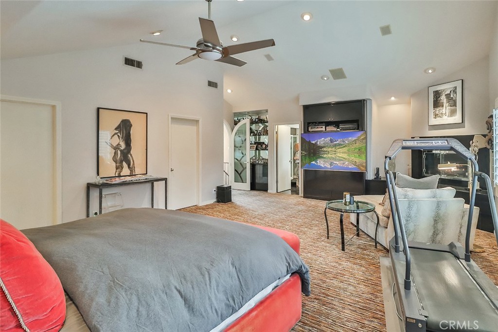 4575 De Celis Place Encino, CA 91436 - Photo 45 of 63 a spacious bedroom with a bed a dresser and a flat screen tv