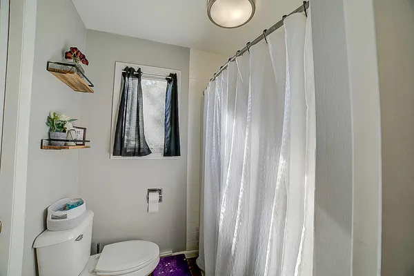 a bathroom with a toilet and a shower curtain