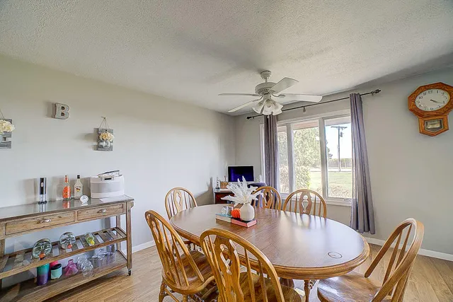 a view of a dining room with furniture a chandelier and a window