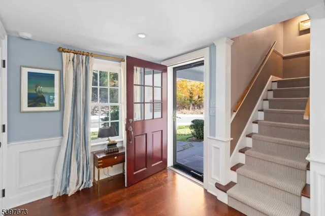 a view of front door with wooden floor and stairs