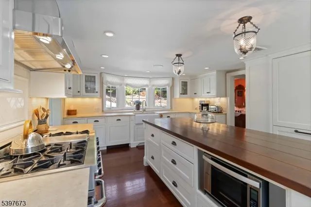 a kitchen with stainless steel appliances a stove oven a sink dishwasher and cabinets with wooden floor