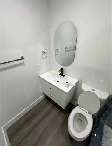 a bathroom with a toilet sink and mirror
