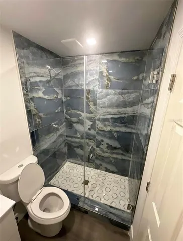 a bathroom with a toilet and a shower