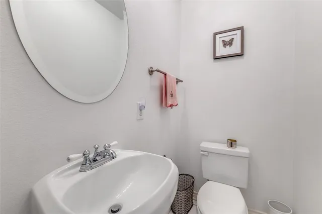 a bathroom with a sink mirror and toilet
