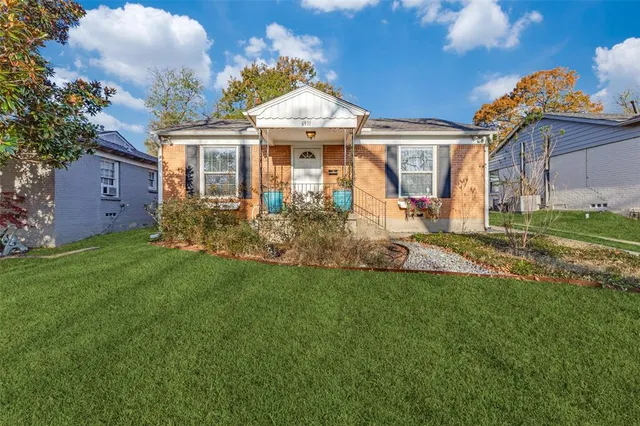 a front view of a house with a garden and plants