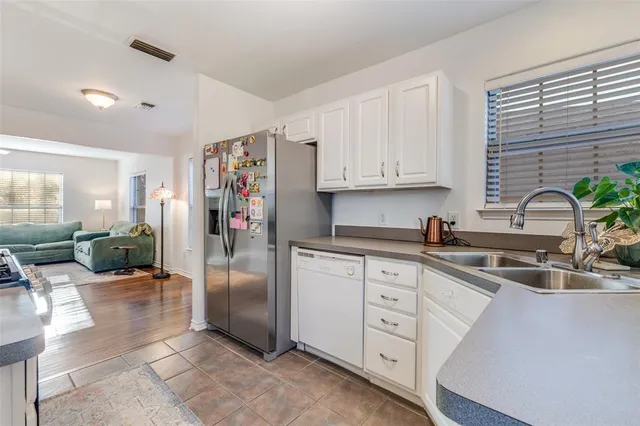 a kitchen that has cabinets appliances a sink and a window