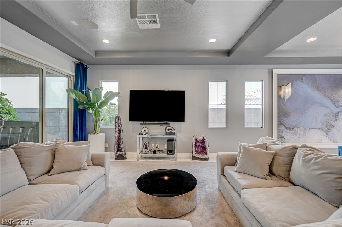 3943 Reyes Avenue Las Vegas, NV 89141 - Photo 6 of 95 Recessed lighting illuminates a well-appointed living room featuring a grand sliding door and tray ceilings.