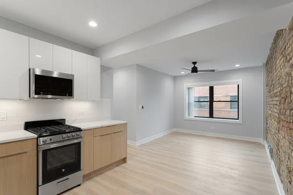 a kitchen with stainless steel appliances a stove microwave and sink