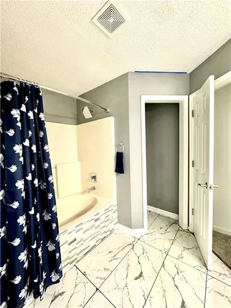 a view of an empty room with closet and windows