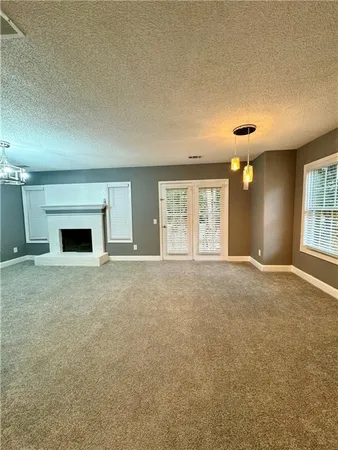 an empty room with a fireplace and windows