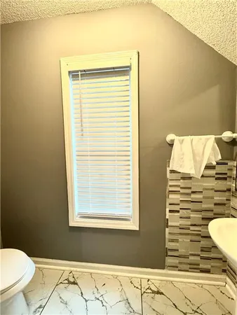 a bathroom with a toilet and a window