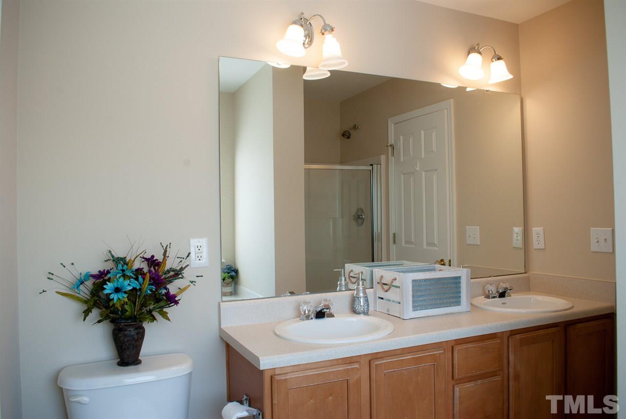2370 Spruce Shadows Lane Raleigh, NC 27614 - Photo 14 of 23 a bathroom with a sink a vanity and a mirror