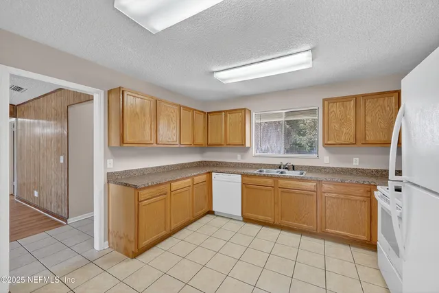 a kitchen with a sink window and cabinets