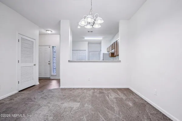 en empty room with wooden floor and mirror