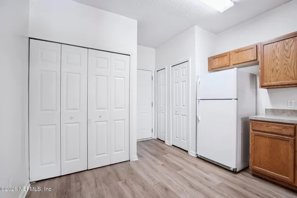 a view of a kitchen with wooden floor and a refrigerator