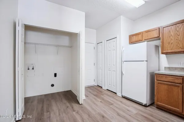 a view of kitchen with wooden floor and electronic appliances