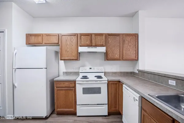 a kitchen with a white stove and white cabinets