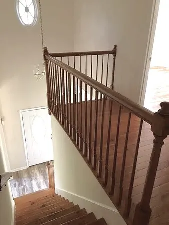 a view of staircase with railing and a rug