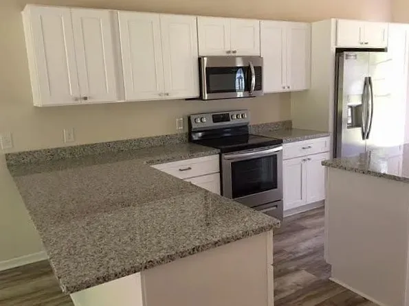 a kitchen with stainless steel appliances granite countertop a sink stove and microwave