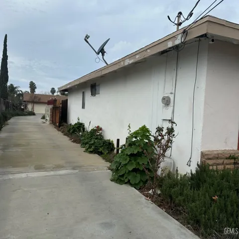 a pathway of a house with potted plants