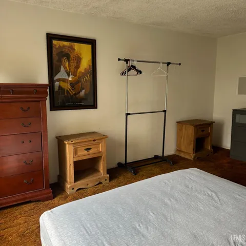 a bedroom with a bed a flat screen tv and a large window