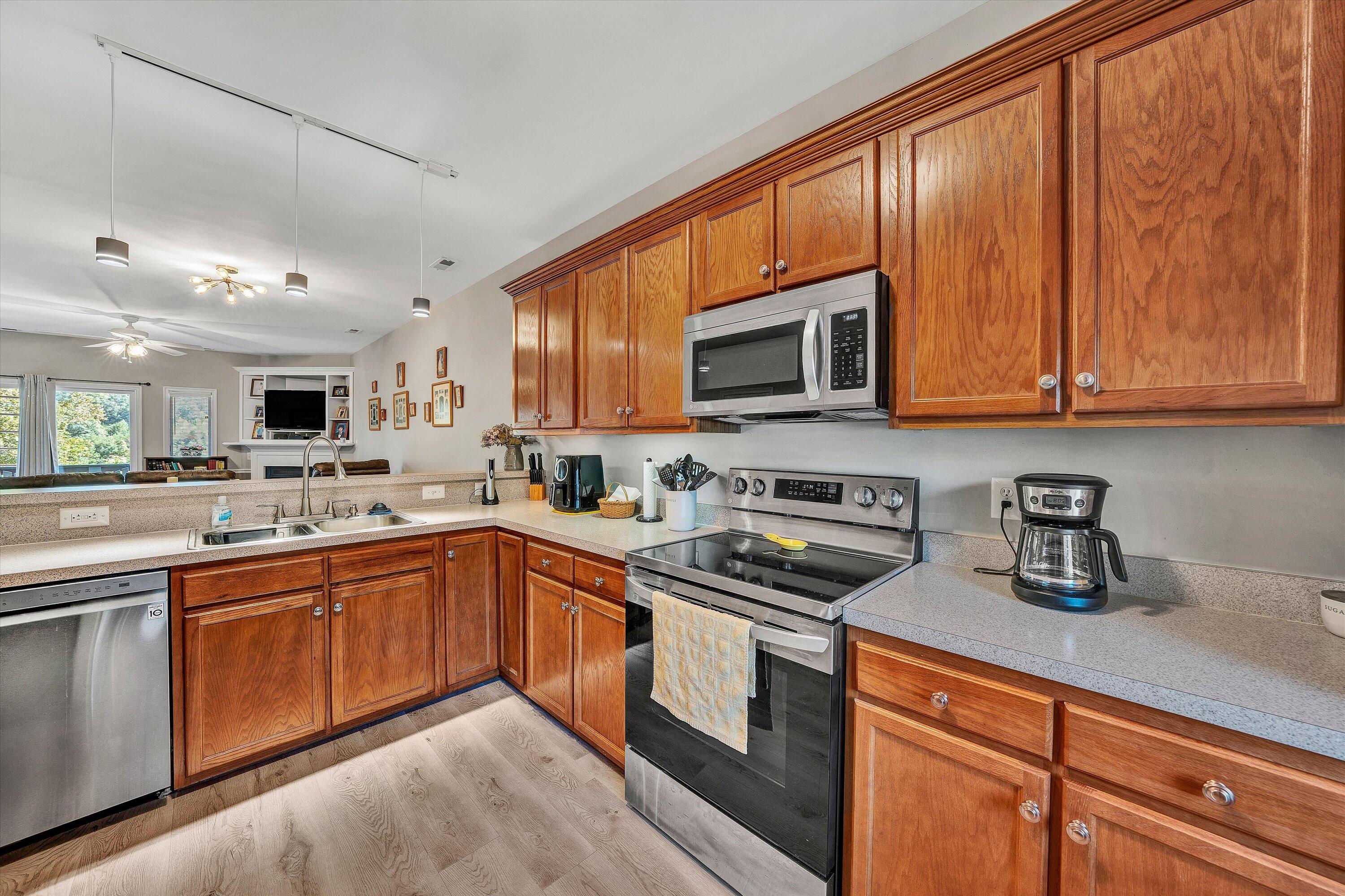 1175 Mariners Way, Unit 54 Huddleston, VA 24104 - Photo 21 of 37 a kitchen with stainless steel appliances granite countertop wooden cabinets a stove top oven a sink and dishwasher